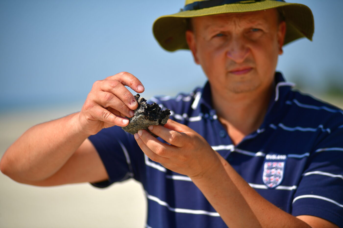 Ruslan Havryliuk holding a heavy fuel oil fragment found on the coast of Tuzly Lagoons National Nature Park