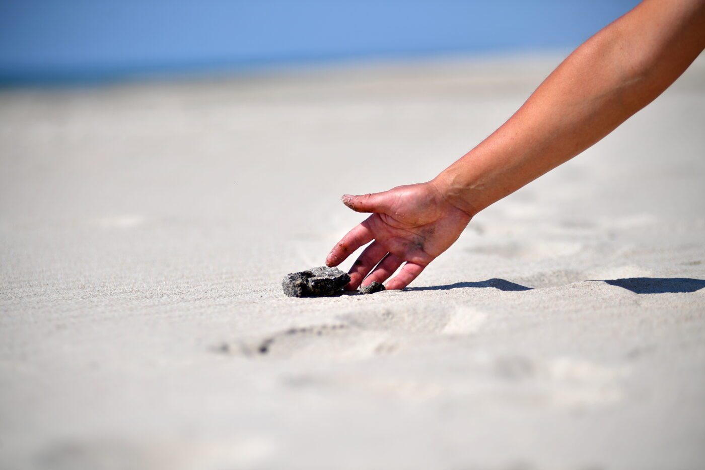 Heavy fuel oil fragment washed onto the sandy Black Sea coast
